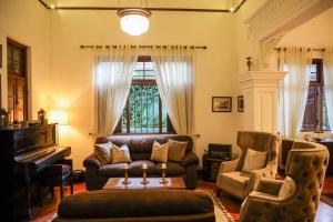 a living room with a couch and a piano at Colonial Residence Kandy Boutique Bungalow in Kandy