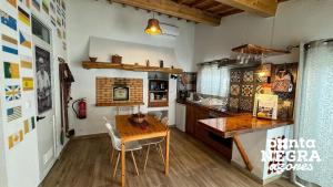 a kitchen with a wooden table and a wooden counter at Alojamento Ponta Negra in Biscoitos