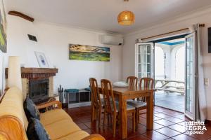 a living room with a table and a fireplace at Casa da Maresia by PontaNegraAzores in Biscoitos
