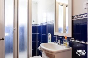 a bathroom with a sink and a toilet and a mirror at Casa da Maresia by PontaNegraAzores in Biscoitos