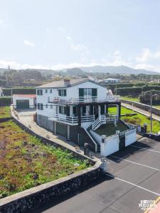a white house with a balcony on a street at Casa da Maresia by PontaNegraAzores in Biscoitos