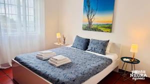 a bedroom with a bed with towels on it at Casa da Maresia by PontaNegraAzores in Biscoitos
