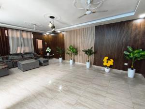 a large living room with plants and a couch at Budget stays in New Delhi