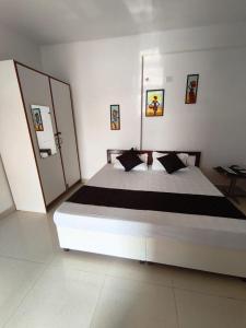 a bedroom with a large white bed with black pillows at Budget stays in New Delhi