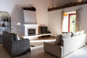 a living room with two chairs and a fireplace at The North House by Ponta Negra Azores in Biscoitos