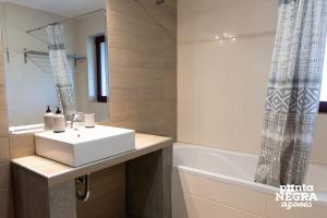 a bathroom with a white sink and a bath tub at The North House by Ponta Negra Azores in Biscoitos +22 photos