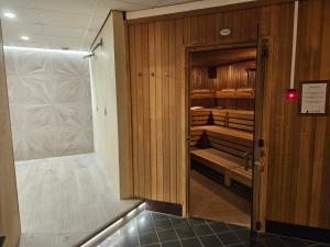 a walk in closet with wooden walls and a door at Residence Terschelling Wellness Waddenresort in Midsland