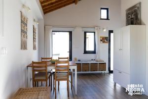 a kitchen and dining room with a table and chairs at Casa da Gente by PontaNegraAzores in Biscoitos