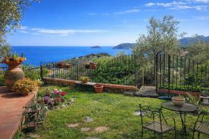 a garden with a fence and a table and chairs at Ai Canarbin - colline di Lerici in Lerici