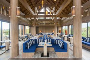 a dining room with blue chairs and tables and windows at Mai Holiday by Mai Khaolak - Adult Zone in Khao Lak +31 photos