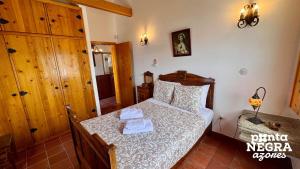 a small bedroom with a bed in a room at Casa da Hortênsia Roxa by Ponta Negra Azores in Praia da Vitória