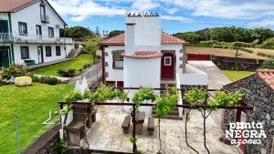 a view of a house with trees in the yard at Casa da Hortênsia Roxa by Ponta Negra Azores in Praia da Vitória