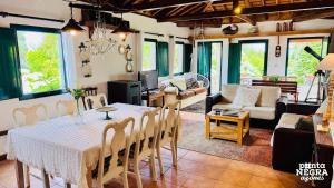 a dining room with a table and a living room at Casa da Serreta by PontaNegraAzores in Serreta
