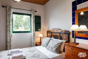 a bedroom with a bed and a window at Casa da Serreta by PontaNegraAzores in Serreta