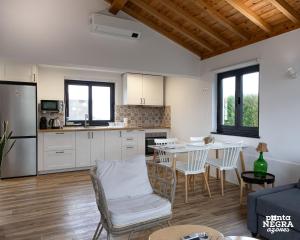 a kitchen and living room with a table and chairs at Wine House by Ponta Negra Azores in Altares