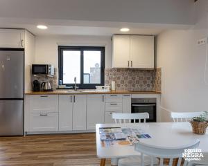 a kitchen with white cabinets and a table at Wine House by Ponta Negra Azores in Altares +11 photos