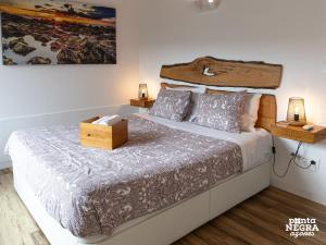 a bedroom with a large bed with a wooden headboard at Wine House by Ponta Negra Azores in Altares