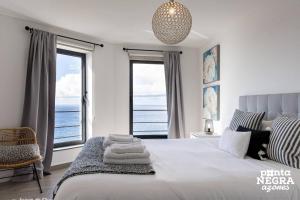 a bedroom with a large bed with a view of the ocean at Casa Maré by PontaNegraAzores in Angra do Heroísmo