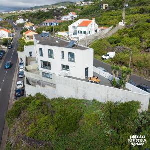 a white building on the side of a road at Casa Maré by PontaNegraAzores in Angra do Heroísmo