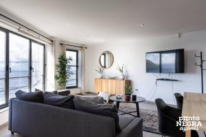a living room with a couch and a tv at Casa Maré by PontaNegraAzores in Angra do Heroísmo