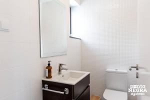 a white bathroom with a sink and a mirror at Casa Maré by PontaNegraAzores in Angra do Heroísmo +14 photos