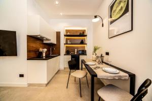a kitchen with a table and chairs in a room at MAMALU - Studios and Suites in Naples