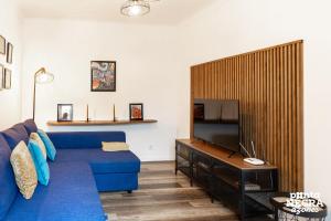 a living room with a blue couch and a tv at The Biscuit House by PontaNegraAzores in Praia da Vitória