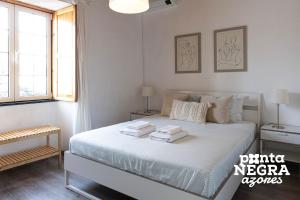 a bedroom with a bed with towels on it at Casa da Gente by PontaNegraAzores in Biscoitos