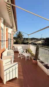 a patio with a white bench and a chair on a house at b&b la terrazza in Lido dei Pini