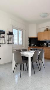 a white dining room table and chairs in a kitchen at b&b la terrazza in Lido dei Pini