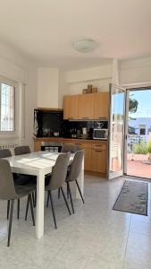 a dining room with a table and chairs and a kitchen at b&b la terrazza in Lido dei Pini