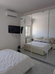 a white bedroom with a bed and a mirror at b&b la terrazza in Lido dei Pini