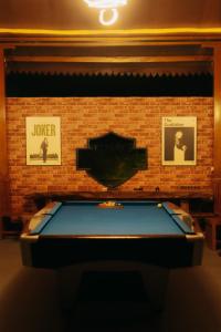 a pool table in front of a brick wall with pictures at Villa de Gema in Selabintana