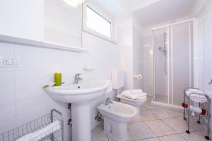a white bathroom with a sink and a toilet at Residence Riva del Lario in Gravedona +114 photos