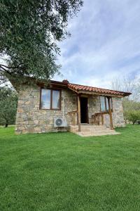 a small stone house in a field of grass at Olympos Stone House in Kumluca