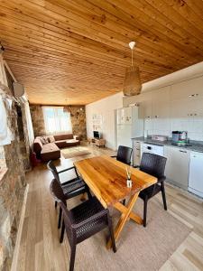 a kitchen and dining room with a wooden table and chairs at Olympos Stone House in Kumluca +16 photos