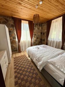 a bedroom with a bed and a wooden ceiling at Olympos Stone House in Kumluca