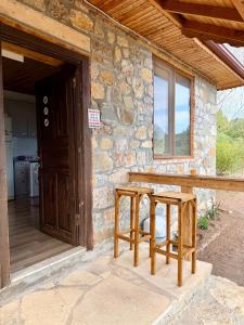 a stone house with two stools in front of a door at Olympos Stone House in Kumluca