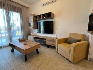 a living room with a couch and a tv at Domus Afitos in Afitos