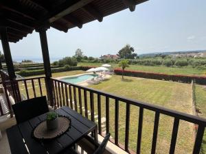 a balcony with a table and a view of a yard at Domus Afitos in Afitos