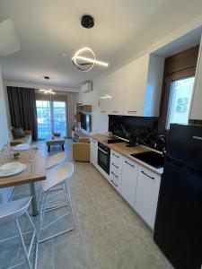 a kitchen with white cabinets and a black refrigerator at Domus Afitos in Afitos