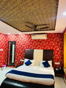 a bedroom with a large bed with red wallpaper at Hostel stay bless in Jaisalmer