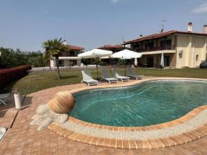a swimming pool with chairs and a house at Domus Afitos in Afitos