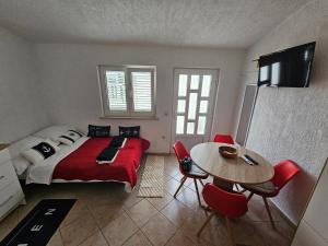 a bedroom with a bed and a table and chairs at Perla Mare in Sumartin