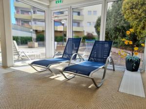 two blue chairs in a room with a large window at Bodensee Loft - 116 m² Traumwohnung in Uhldingen-Mühlhofen