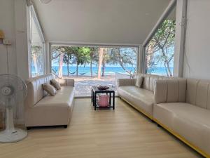 a living room with two couches and a table at Tharnvara Resort in Ban Khok Sung