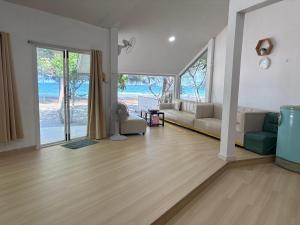 a living room with a couch and a table at Tharnvara Resort in Ban Khok Sung