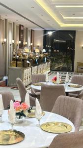 a restaurant with tables and chairs with flowers on them at ANANTYA BANQUET and HOTEL in Sonīpat