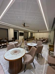 a large room with tables and chairs and a room with tables at ANANTYA BANQUET and HOTEL in Sonīpat