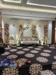 a living room with a couch and flowers on a wall at ANANTYA BANQUET and HOTEL in Sonīpat
